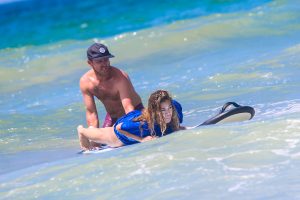 Teacher guiding new surfer