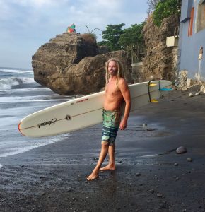 Rory on the beach with a surfboard